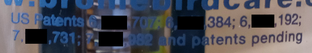 Redacted photo of patent marking notice on bird feeder product, which reads, "US Patents 6,[],707; 6,[],384; 6,[],192; 7,[],731; 7,[],982 and patents pending"