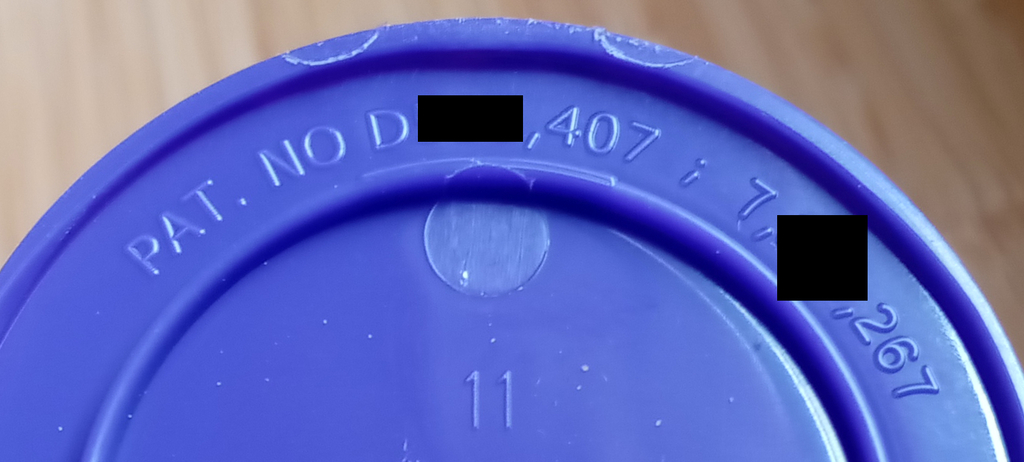 Redacted photo of patent marking notice on bird feeder product, which reads, "PAT. NO D[],407 ; 7,[]267"
