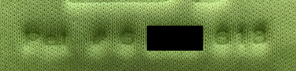 Redacted photo of patent marking notice on bicycle shorts chamois pad, reading "Pat # 6 [] 618"