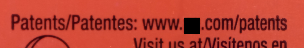 photo of powdered laundry detergent box with "Patents/Patentes: www.[].com/patents" virtual patent marking notice printed on the exterior of the package